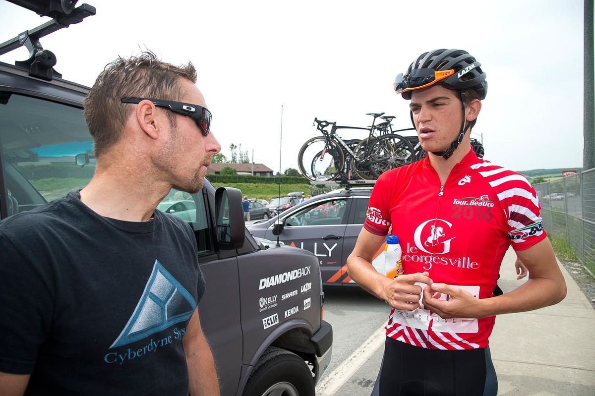 Sepp Kuss, in the red climber's jersey at Tour de Beauce, talks with Rally Cycling director Eric Wohlberg