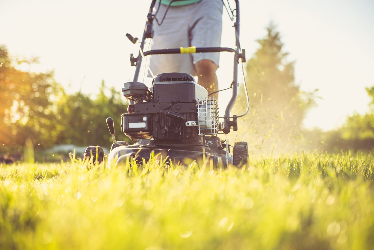 A person mows a lawn.