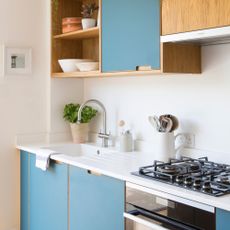 White kitchen with a white worktop and blue cabinets