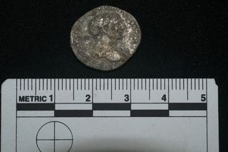 A silver coin discovered in a Roman-era grave in the United Kingdom.