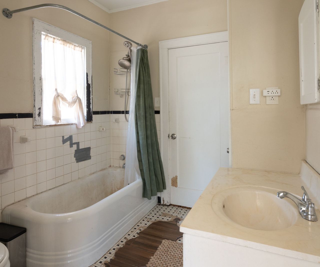 Bathroom with white bath tub, marble sink, tiles and cream walls