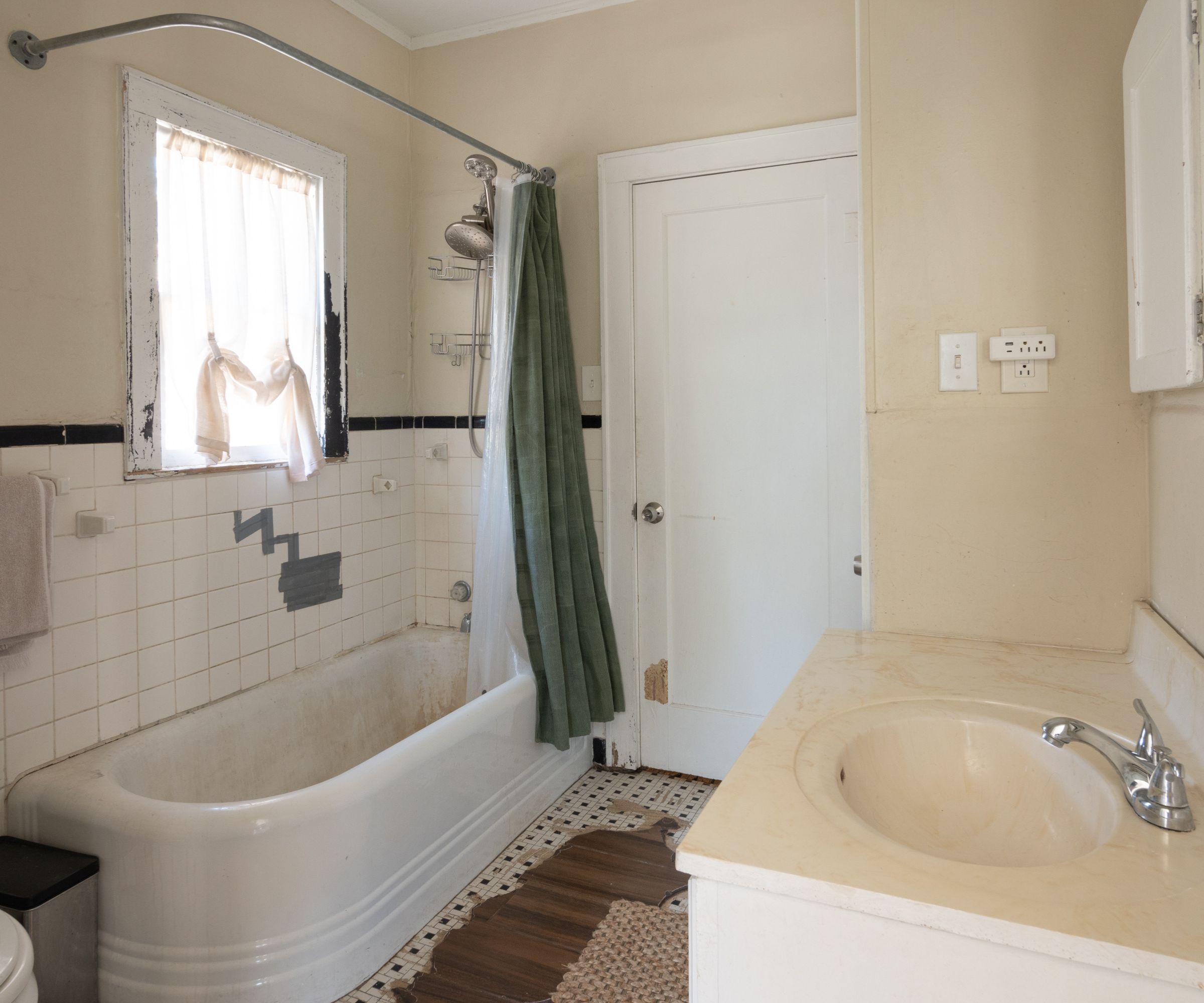 Bathroom with white bath tub, marble sink, tiles and cream walls