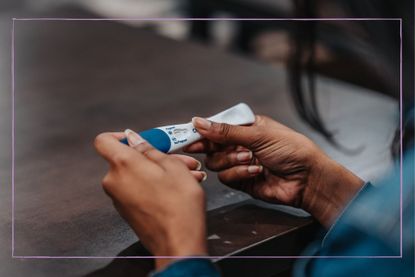 What to do when you find out you’re pregnant illustrated by hands holding a pregnancy test