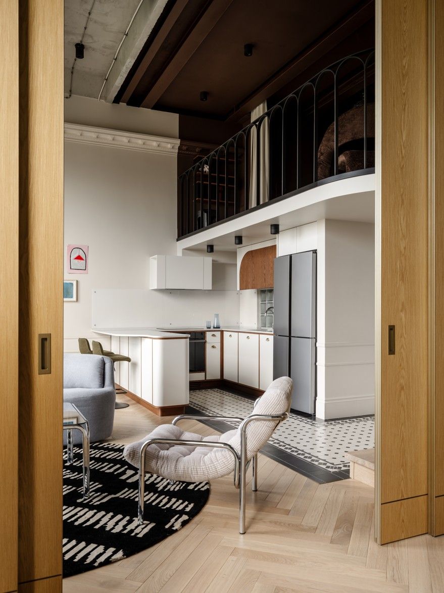 An open plan kitchen with a curved breakfast bar and white walls