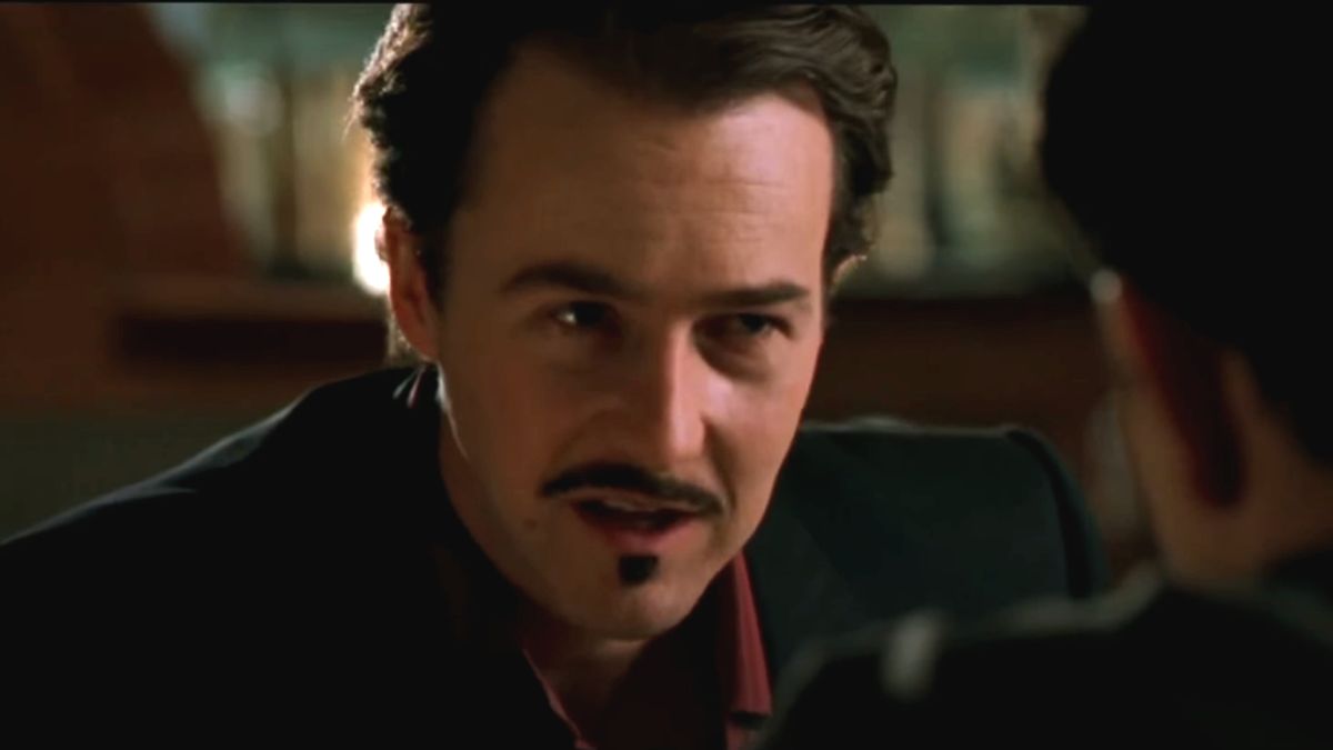 Edward Norton speaks at a restaurant table in The Italian Job.