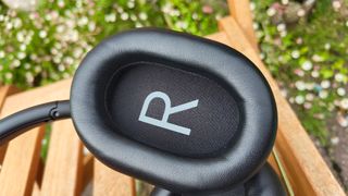 Austrian Audio Hi-X25BT over-ear headphones on wooden bench close-up on inside of earcup