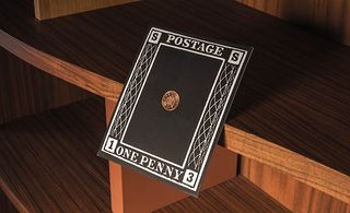 oversized black postage stamp affixed with a copper penny