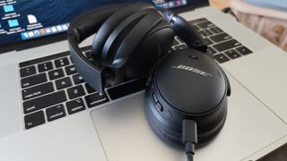 The Bose QuietComfort 45 charging on a MacBook Pro