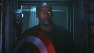 Anthony Mackie eyes his surroundings suspiciously with shield in hand in Captain America: Brave New World.