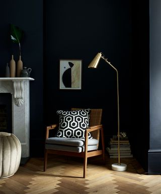 Black living room paint ideas with a wooden chair and graphic cushion.