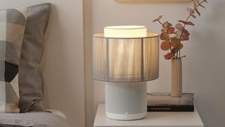Symfonisk Table Lamp speaker (Gen 2) with textile shade next to a bed