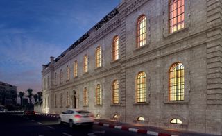 Outside view of stone building with arched windows and black frames