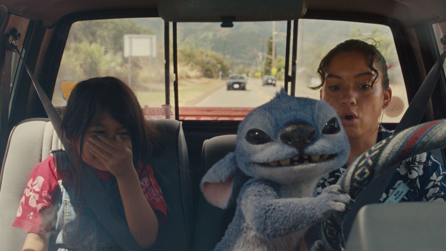 Lilo takes the wheel of a car in Lilo &amp;amp; Stitch, while Maia Kealoha as Lilo Pelekai laughs.