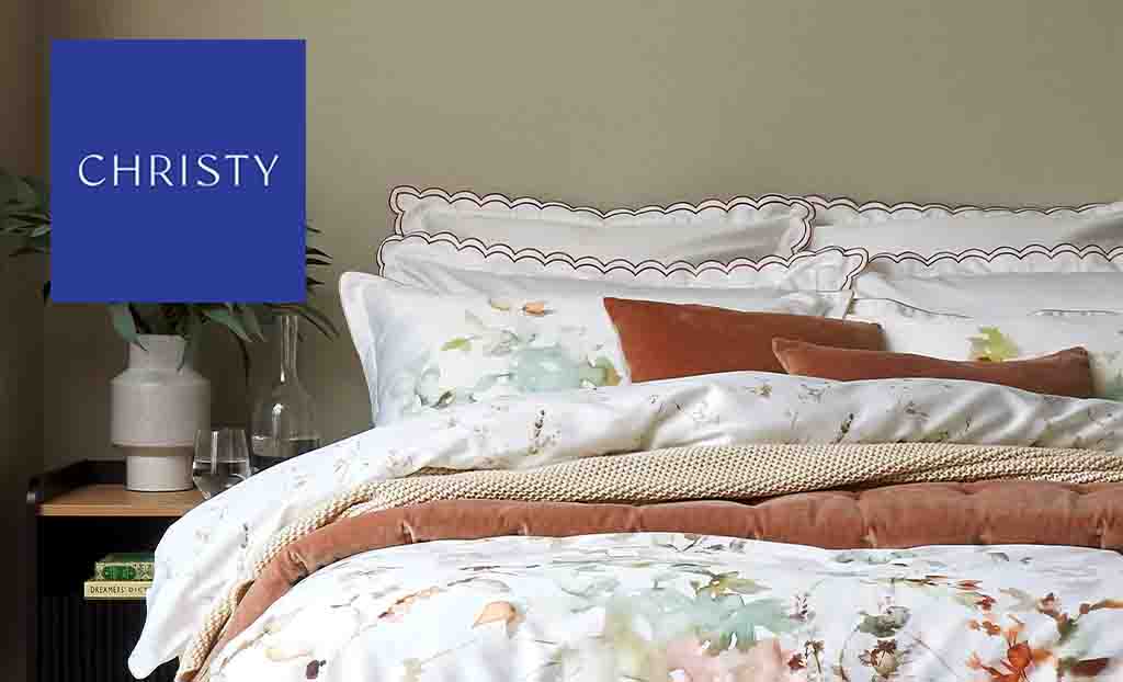 Christy logo in top left with a picture of a double bed with white and brown bedding 