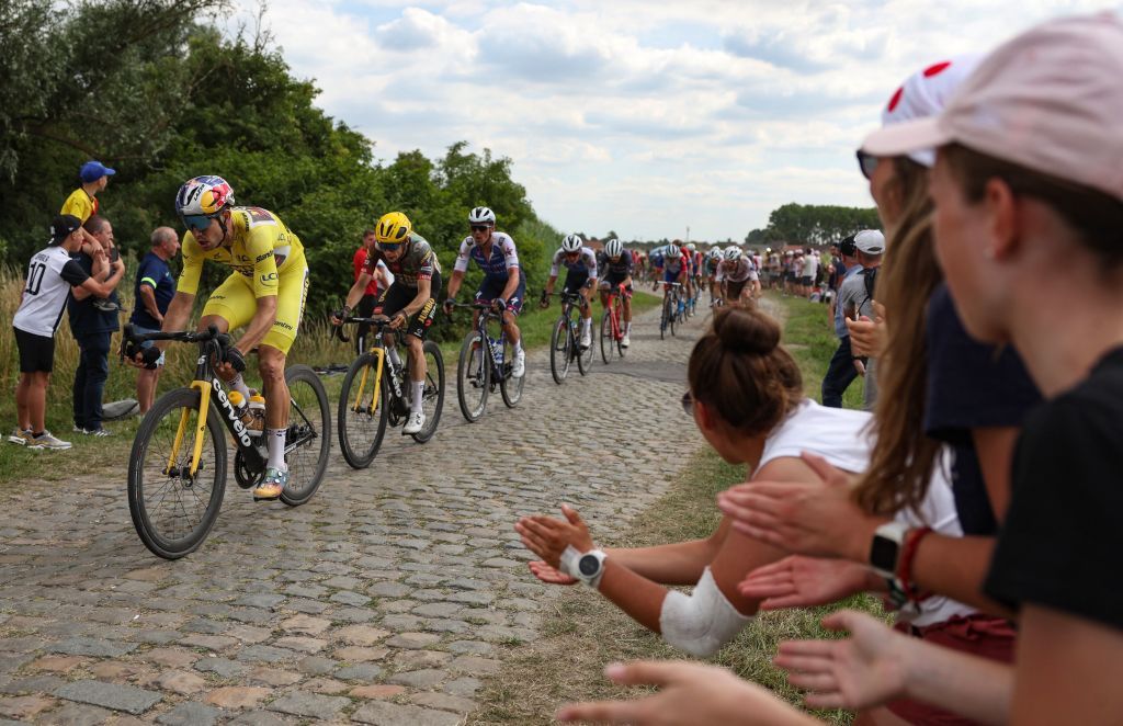 JumboVisma teams Belgian rider Wout Van Aert L wearing the overall leaders yellow jersey cycles across a cobblestone sector during the 5th stage of the 109th edition of the Tour de France cycling race 1537 km between Lille and Arenberg Porte du Hainaut in northern France on July 6 2022 Photo by Thomas SAMSON AFP Photo by THOMAS SAMSONAFP via Getty Images