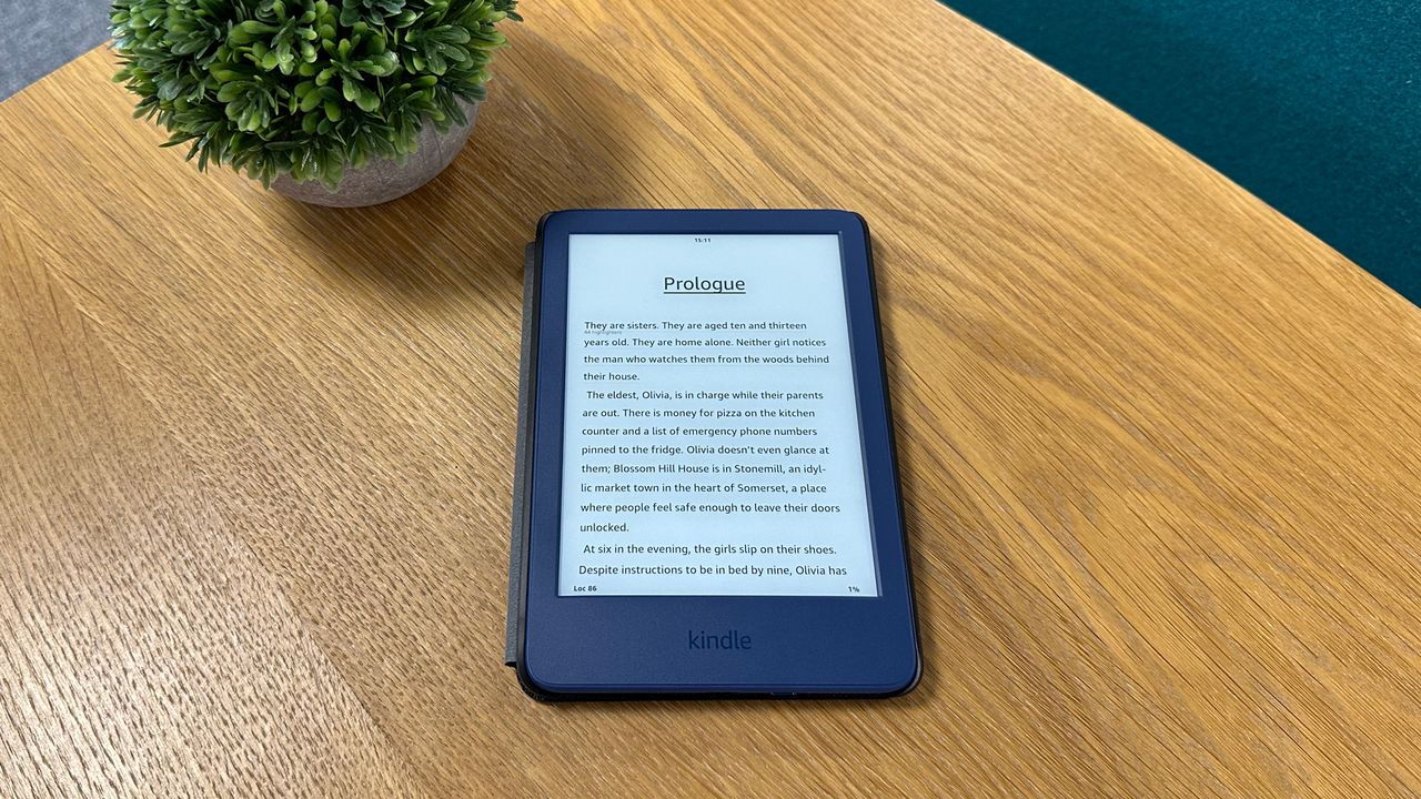 Kindle on wooden table next to plant