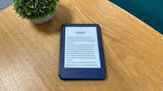 Kindle on wooden table next to plant