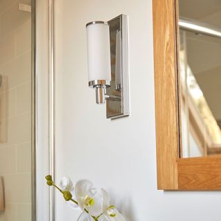 bathroom with wall mounted lights and mirror