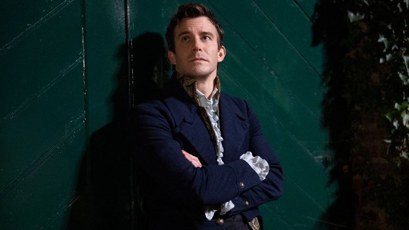 Benedict looking up with his arms crossed in Season 4 of Bridgerton. 