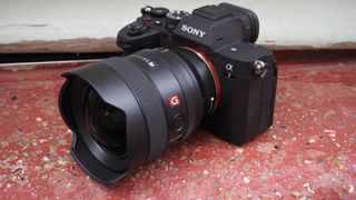 Sony A7 IV on red surface with lens attached