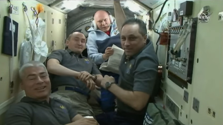 NASA astronaut Mark Vande Hei (left) and Russian cosmonauts Pyotr Dubrov (center left) and Anton Shkaplerov (right) bid farewell to their Expedition 66 crewmates on the International Space Station on March 30,2022. Expedition 67 cosmonaut Oleg Artemyev is seen in the background. He will remain on the space station.