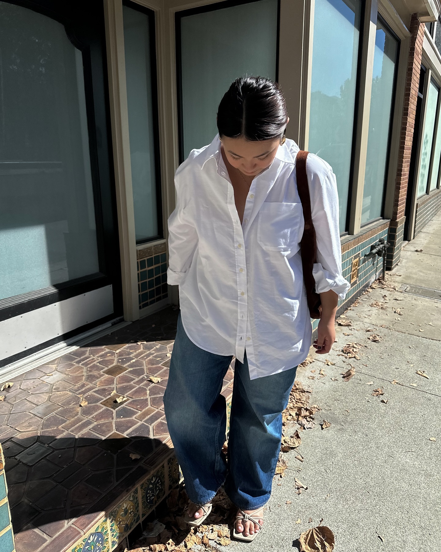 An image of @marina_torres wearing baggy jeans with a white button-down shirt.