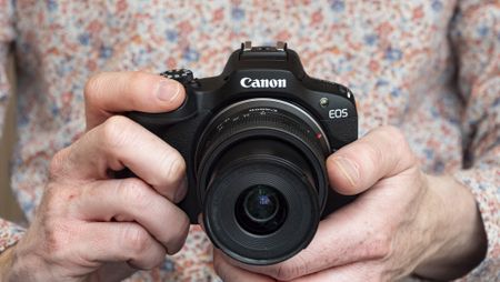 Canon EOS R100 camera in the hand