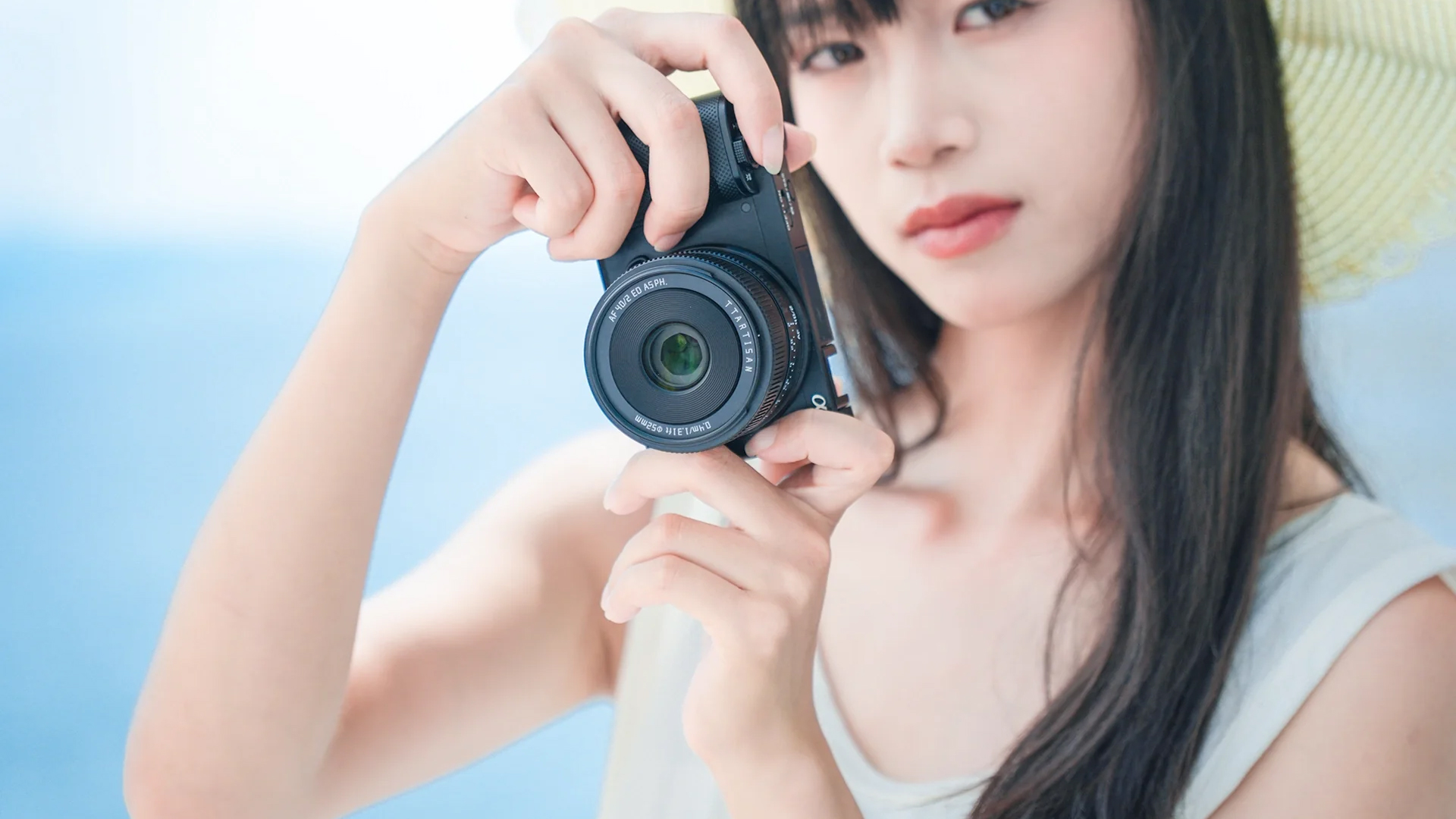 The TTArtisan AF 40mm f/2 held in a photographer&#039;s hands