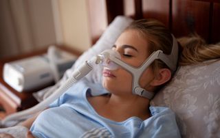 A woman using a medical device to help stop snoring