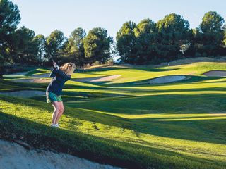 Katie Dawkins demonstrating a shot with the golf ball below her feet