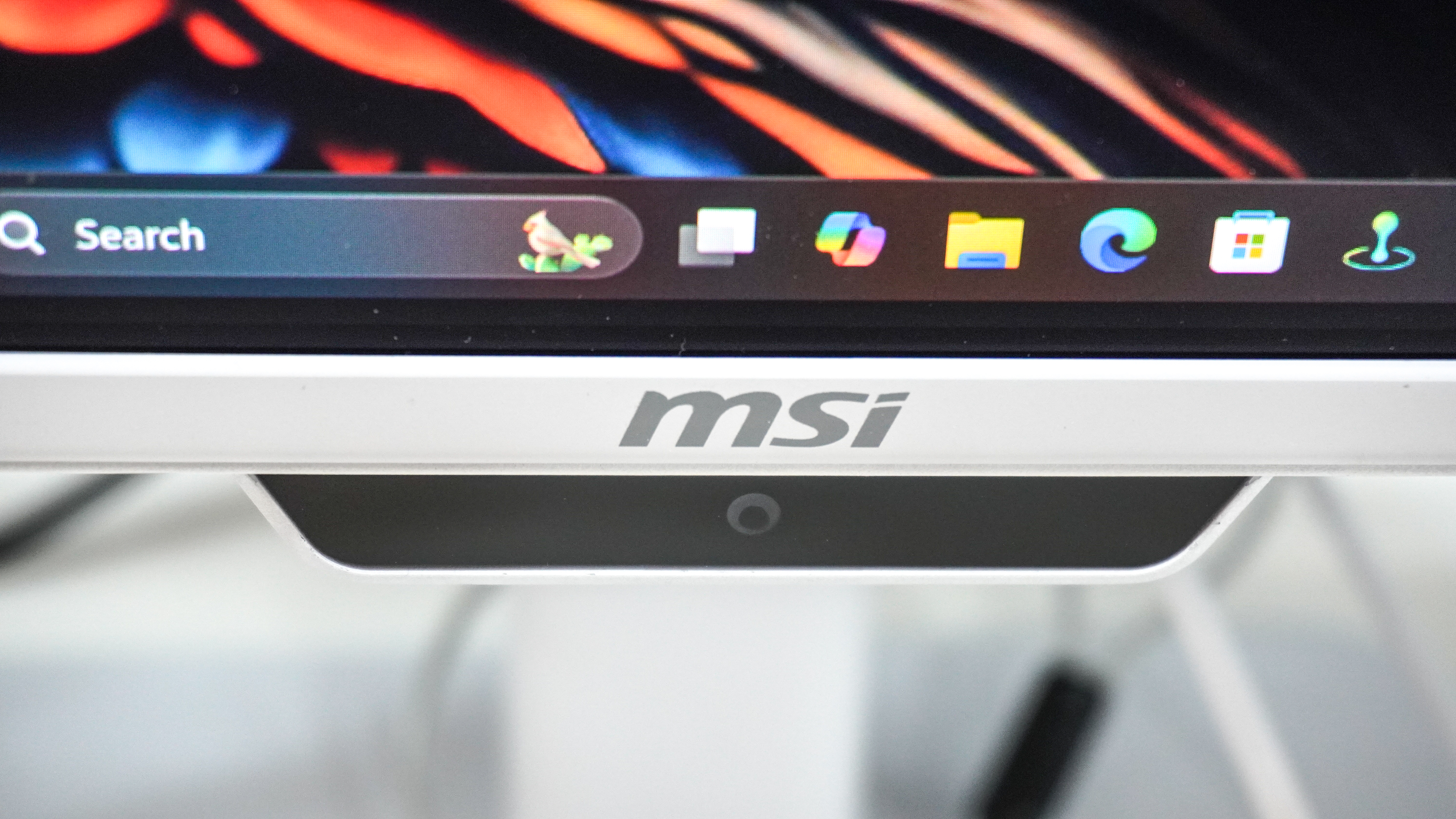 The AI Care Sensor underneath the MSI logo on the PRO MAX 271UPXW12G monitor