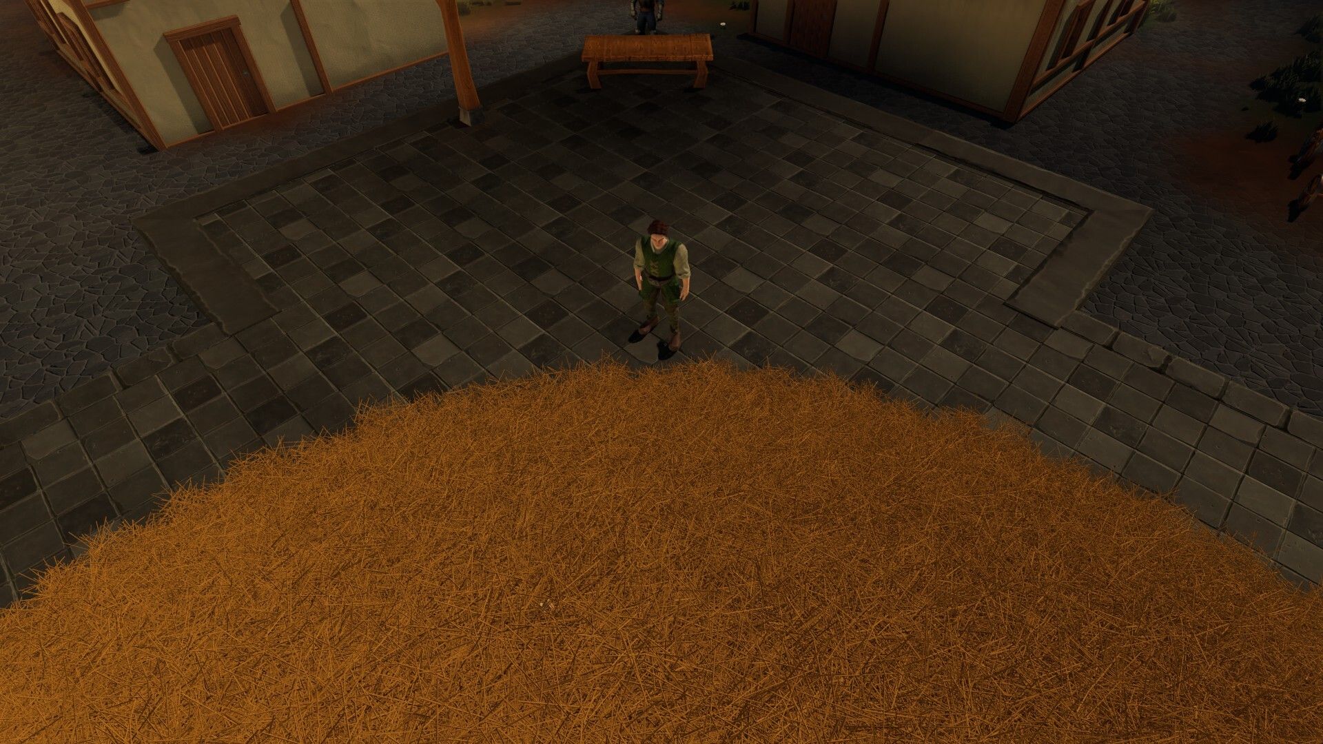 Man stands near a massive haystack