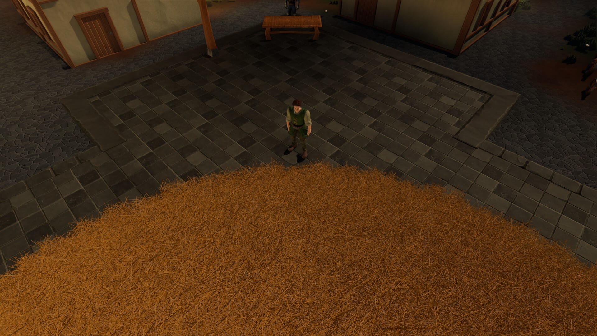 Man stands near a massive haystack