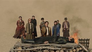 The Shadow and Bone season 2 cast assemble in front of a pyre with The Darkling lying on it in season 2 episode 8.