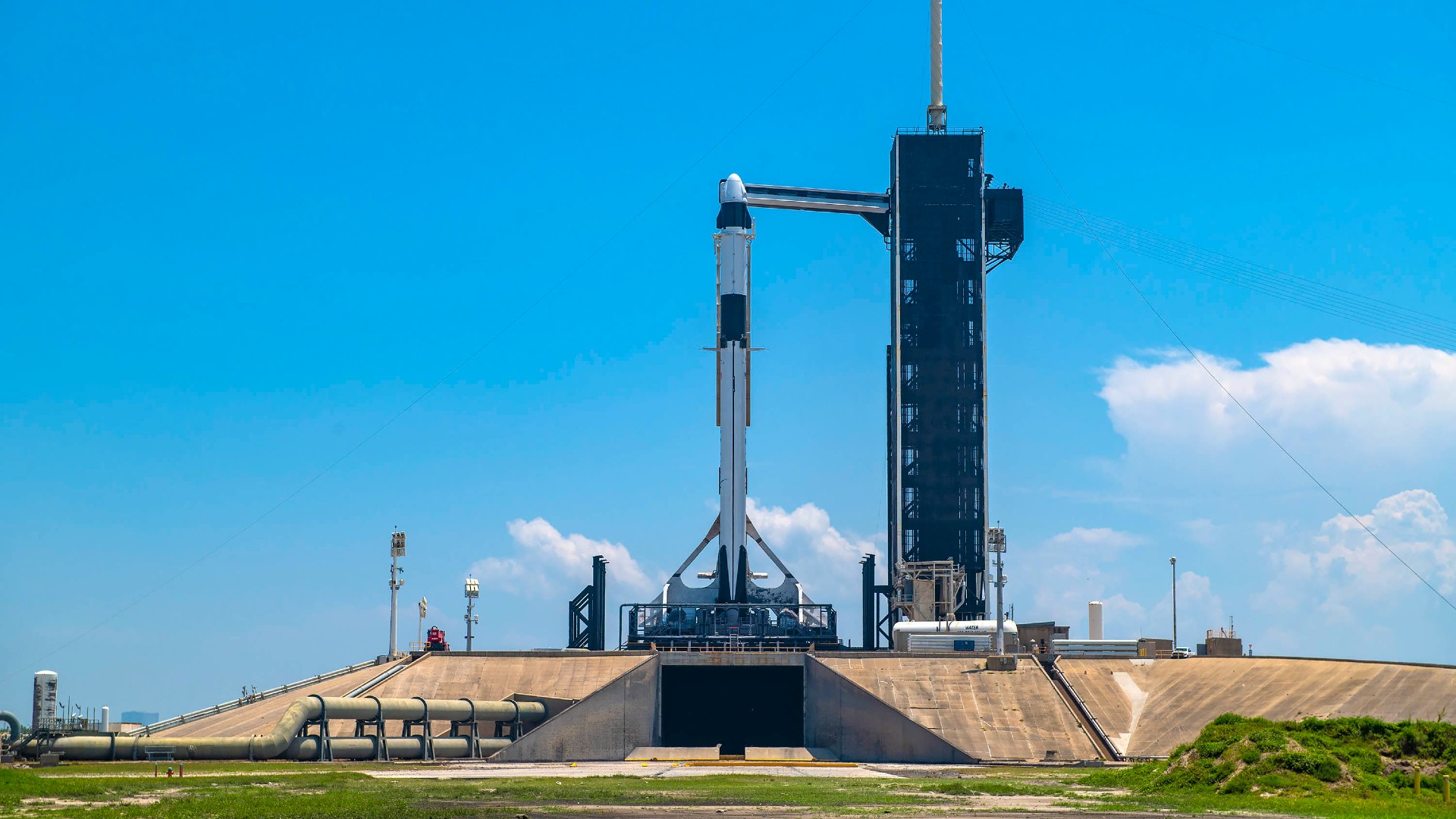 A white rocket on a launch pad under a blue sky