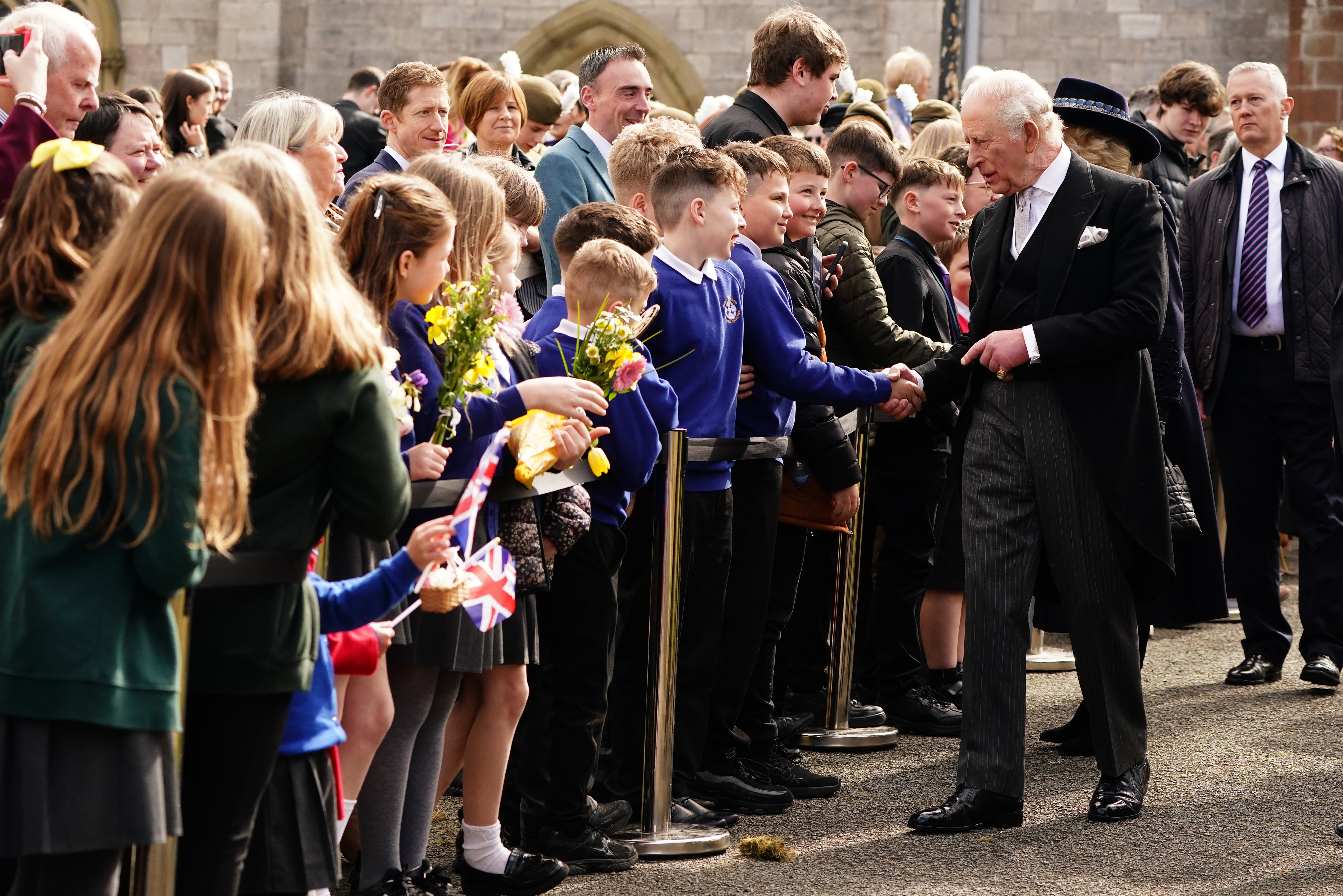 King Charles wearing a suit talking to members of the public