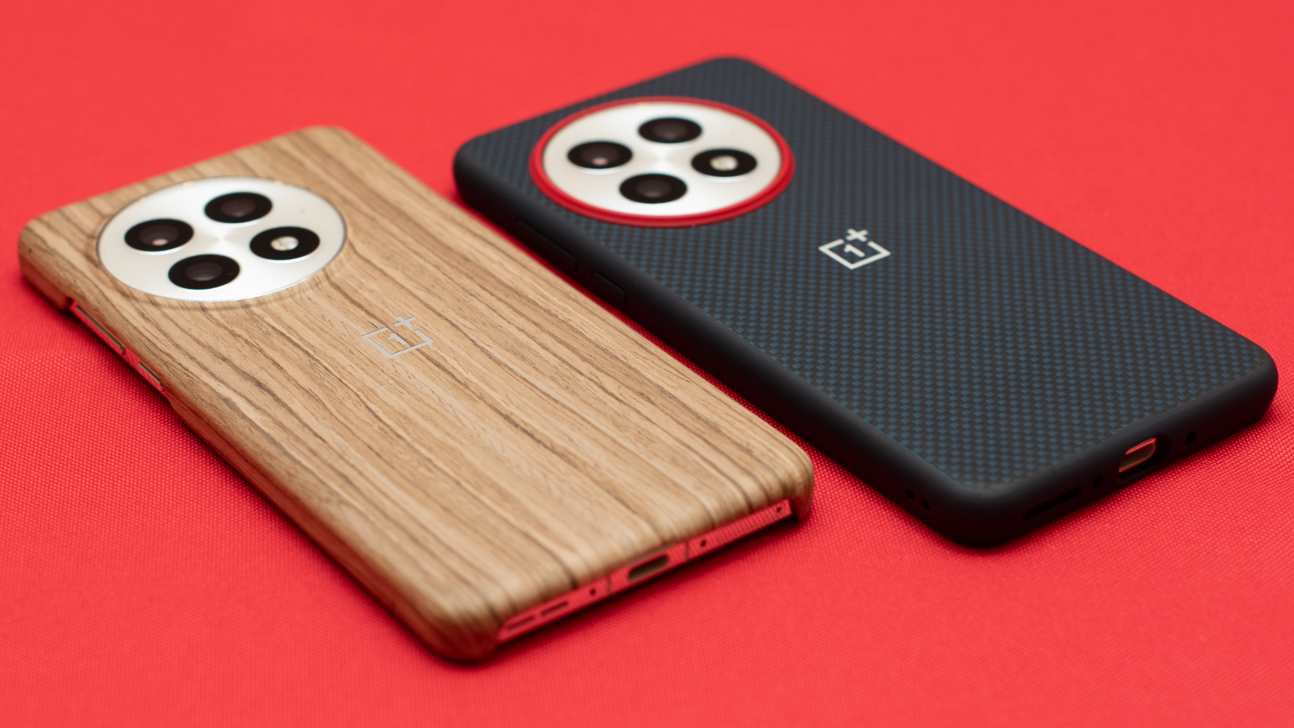 OnePlus 13 in wooden case and aramid fiber case on red table top