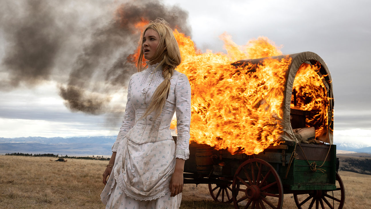 Isabel May as Elsa in 1883 in front of a burning wagon