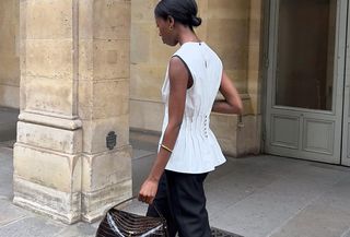 Woman wearing an elegant white top with black trousers.