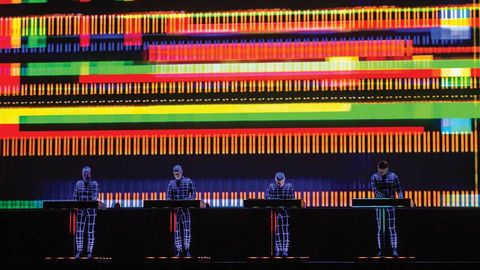 Kraftwerk on stage with laser lights and neon suits