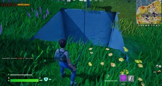 Fortnite - a player stands in front of a hole in the ground