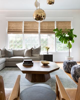 living room with gray sofa wooden coffee table and golden pendant lights