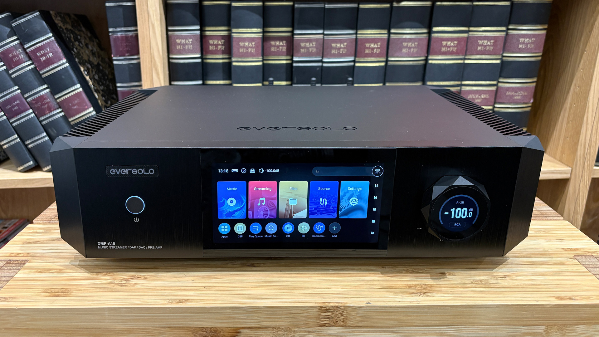 Eversolo DMP-A10 streaming amplifier on wooden hi-fi rack in front of bookcase