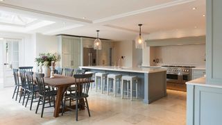 large open plan kitchen diner with grey units and stone floor