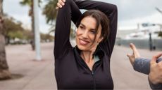 Woman stretching outside, smiling