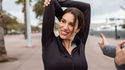 Woman stretching outside, smiling