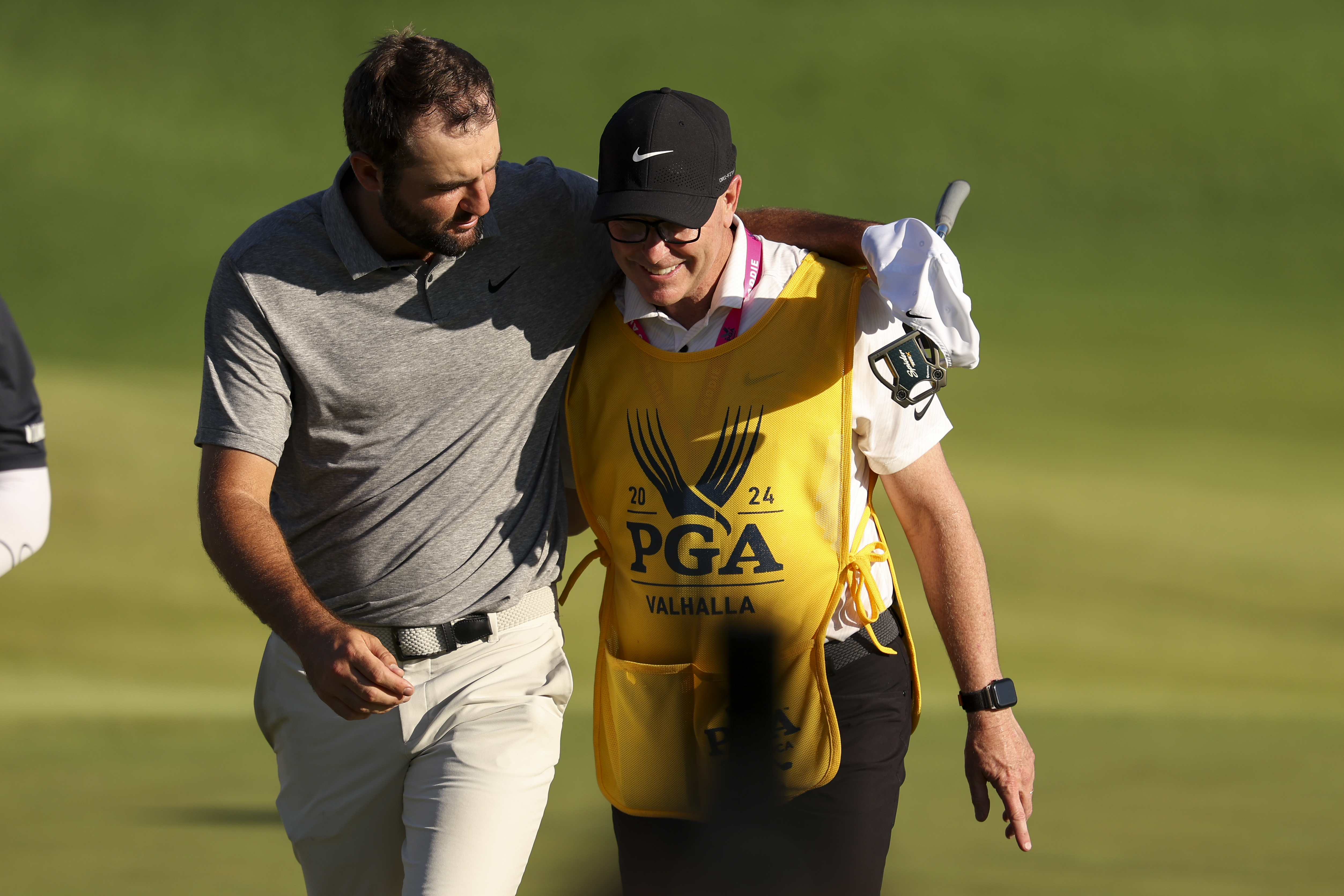 Scottie Scheffler puts his arm round his caddie