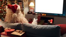 Santa Claus sitting on the sofa at home and watching TV