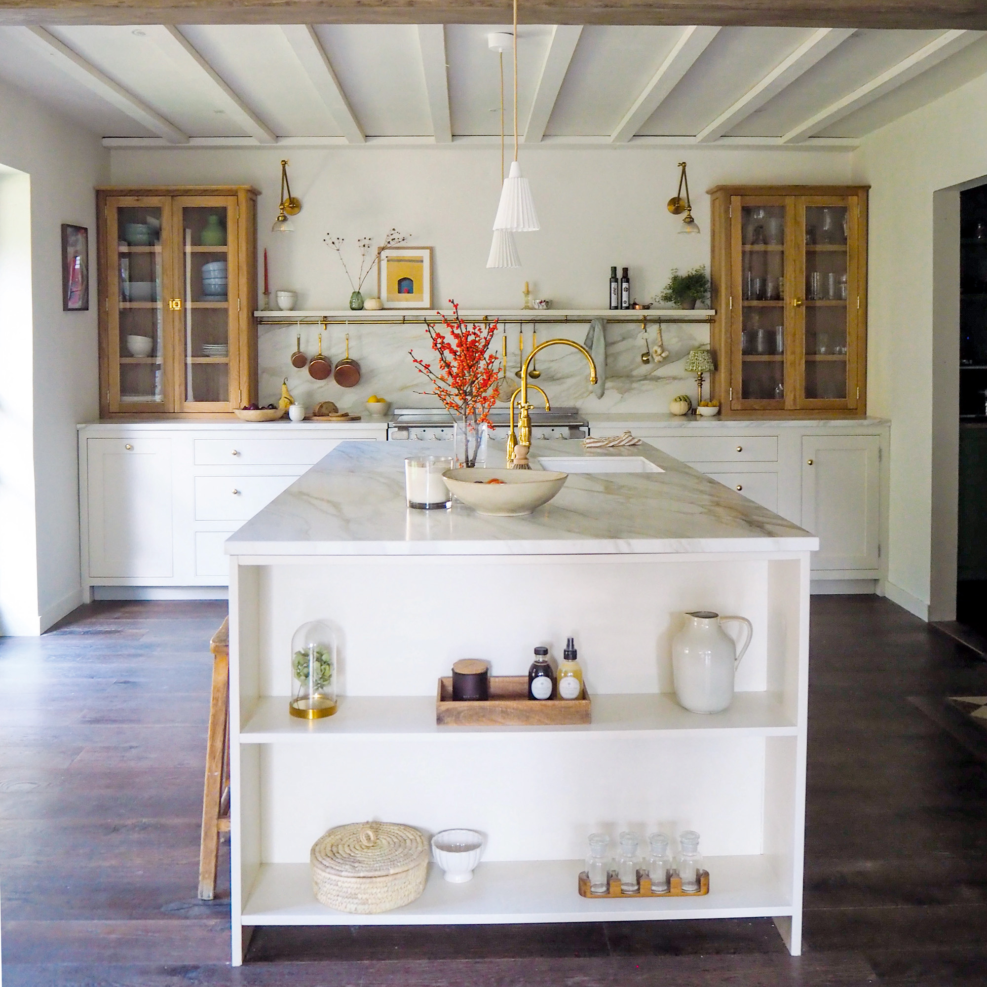 kitchen with neutral white walls and cabinetry and island with dark wood flooring and unpainted wooden unit cabinets