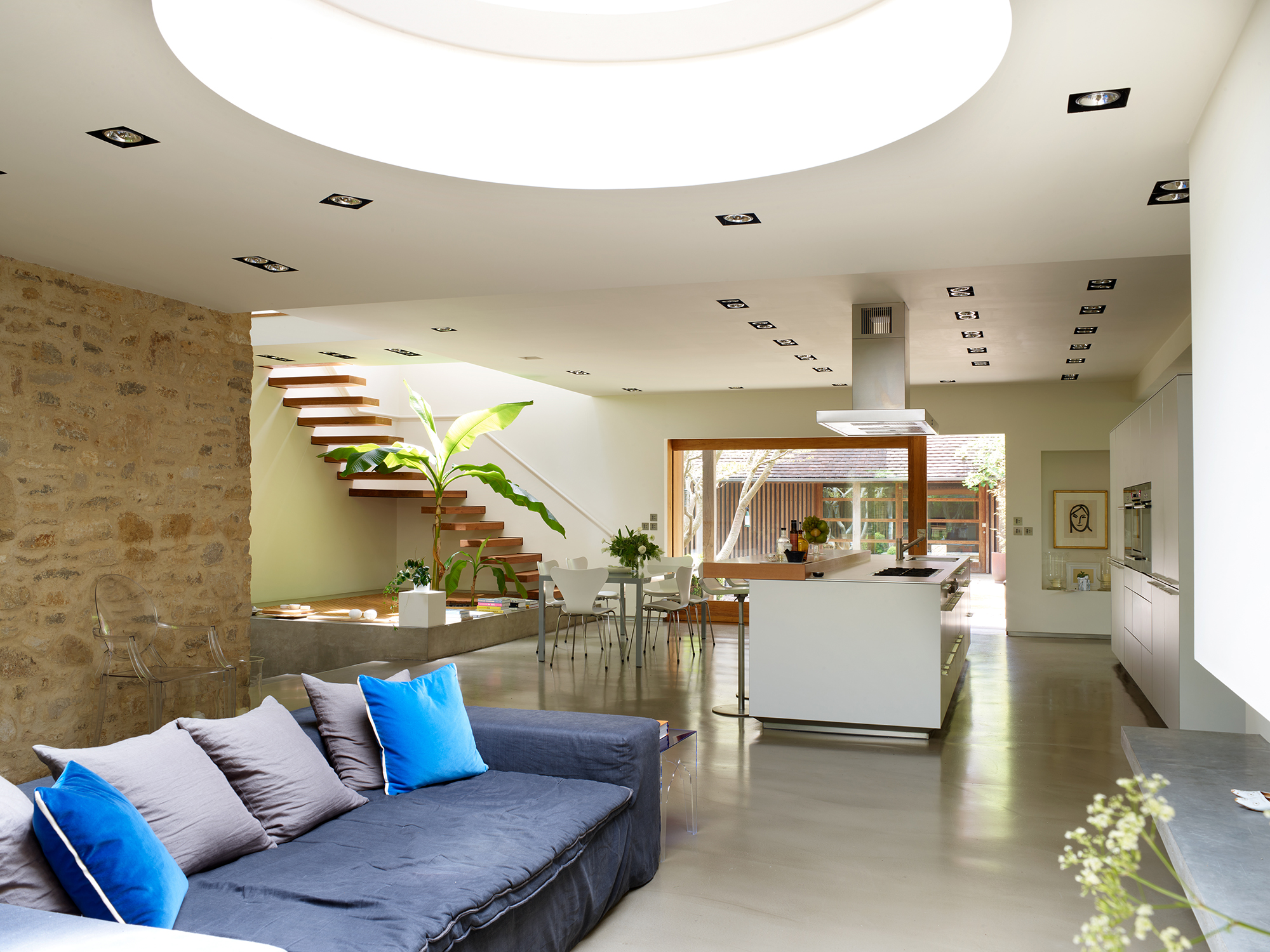 sleek white open plan kitchen with gray sofa area